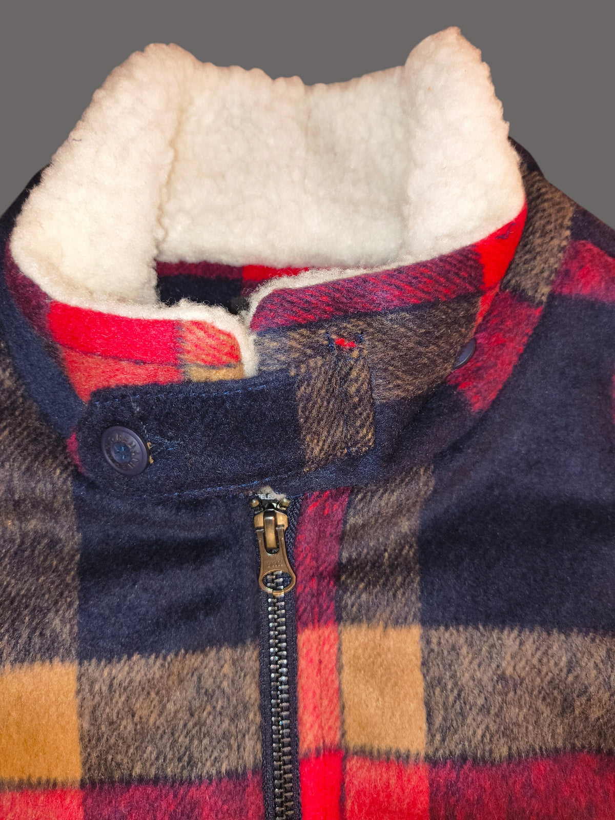 Awsum Thrift The One Hundred Jacket featuring a red, black, and tan plaid wool exterior with a white sherpa lining.