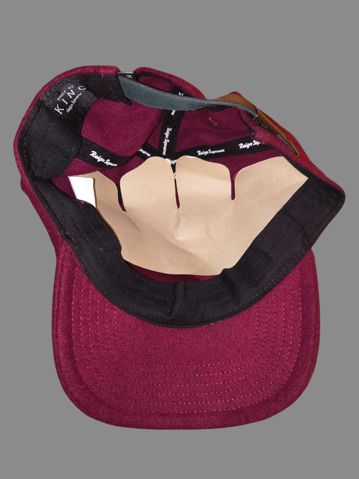 Awsum Thrift King Apparel maroon wool dad hat interior showing Reign Supreme branding tape and black sweatband