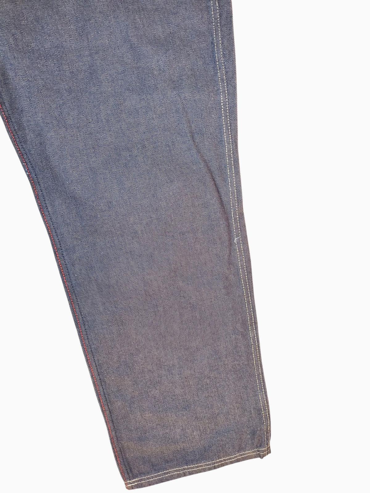 Awsum Thrift vintage Marc Ecko dark indigo raw denim jeans leg with red contrast stitching and cross-hatch texture
