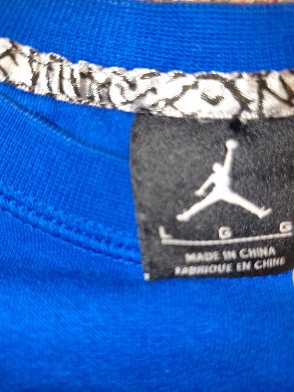 Awsum Thrift blue Jordan shirt featuring a black neck label with the iconic Jumpman logo and elephant print trim.