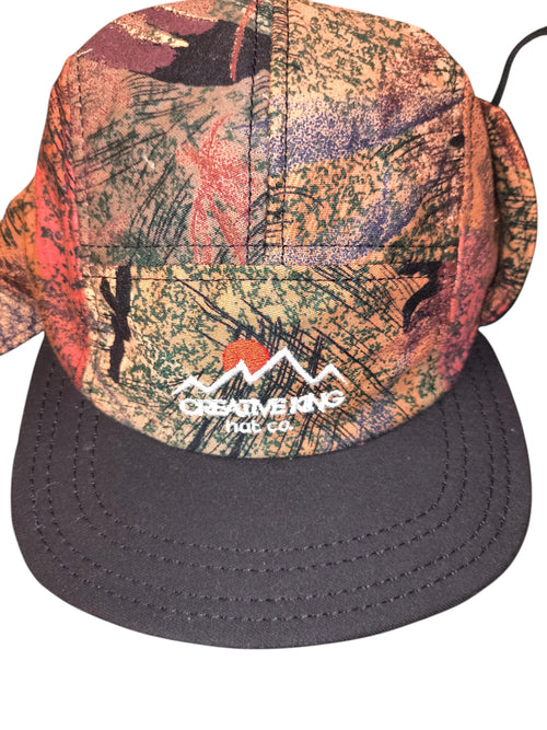 Awsum Thrift Creative King Hat Co. 5-panel camper hat with earth-toned camo tapestry fabric and ear flaps.