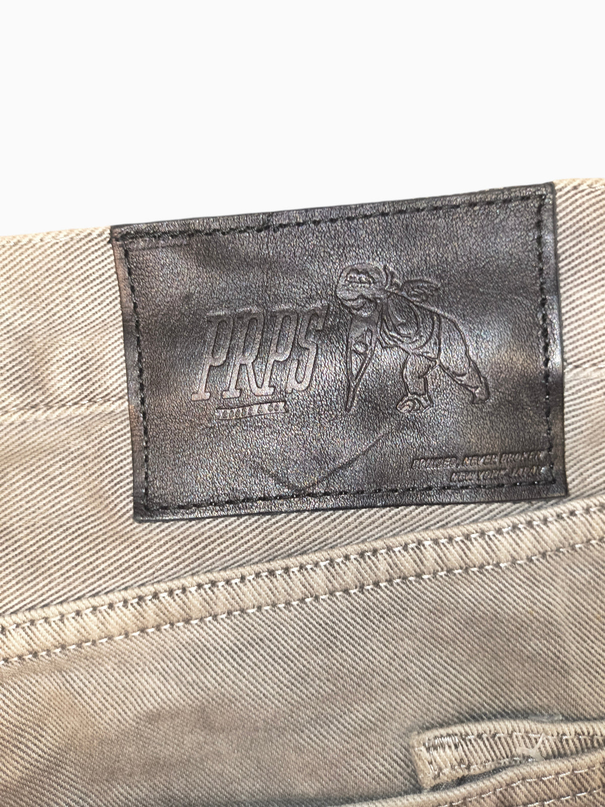 Awsum Thrift PRPS gray jeans featuring a black leather back patch with embossed logo and angel graphic