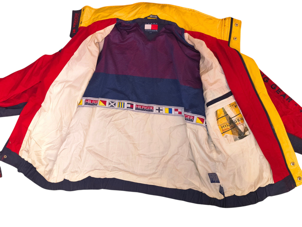 Awsum Thrift vintage Tommy Hilfiger jacket interior featuring a hideaway hood, mesh lining, and nautical flag trim.