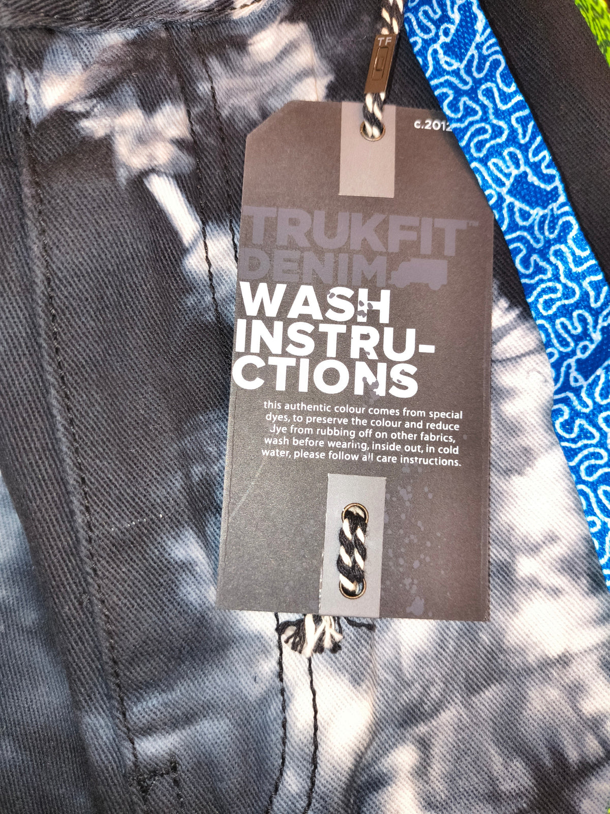 Awsum Thrift Trukfit Denim shorts featuring a black and white tie-dye pattern with a branded wash instruction tag