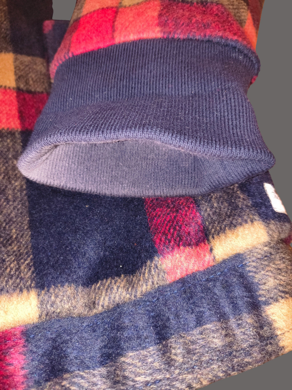 Awsum Thrift The One Hundred Jacket featuring a navy blue ribbed cuff and a red and navy plaid fleece fabric