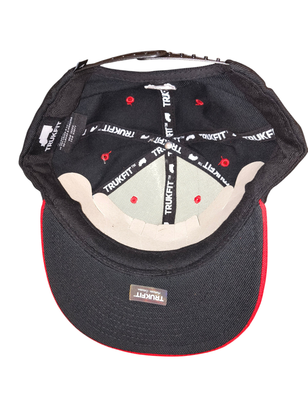 Awsum Thrift Trukfit snapback hat interior showing branded seam tape and red eyelets on a black crown