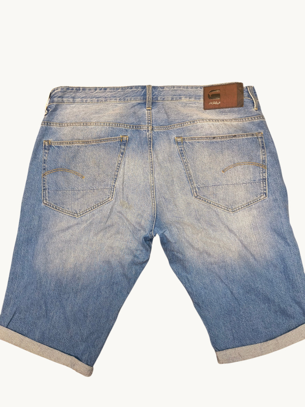 Awsum Thrift G-Raw light wash denim jean shorts with a brown leather back patch and cuffed hems