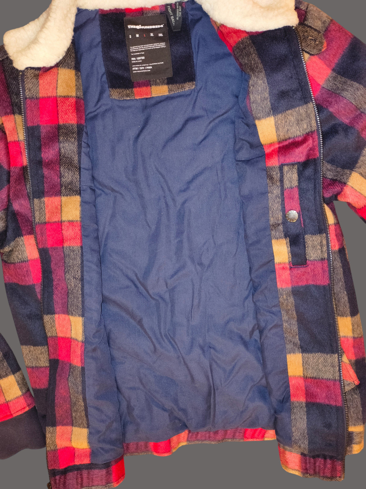 Awsum Thrift The One Hundred Jacket featuring a red, yellow, and navy plaid flannel exterior with a blue lining.