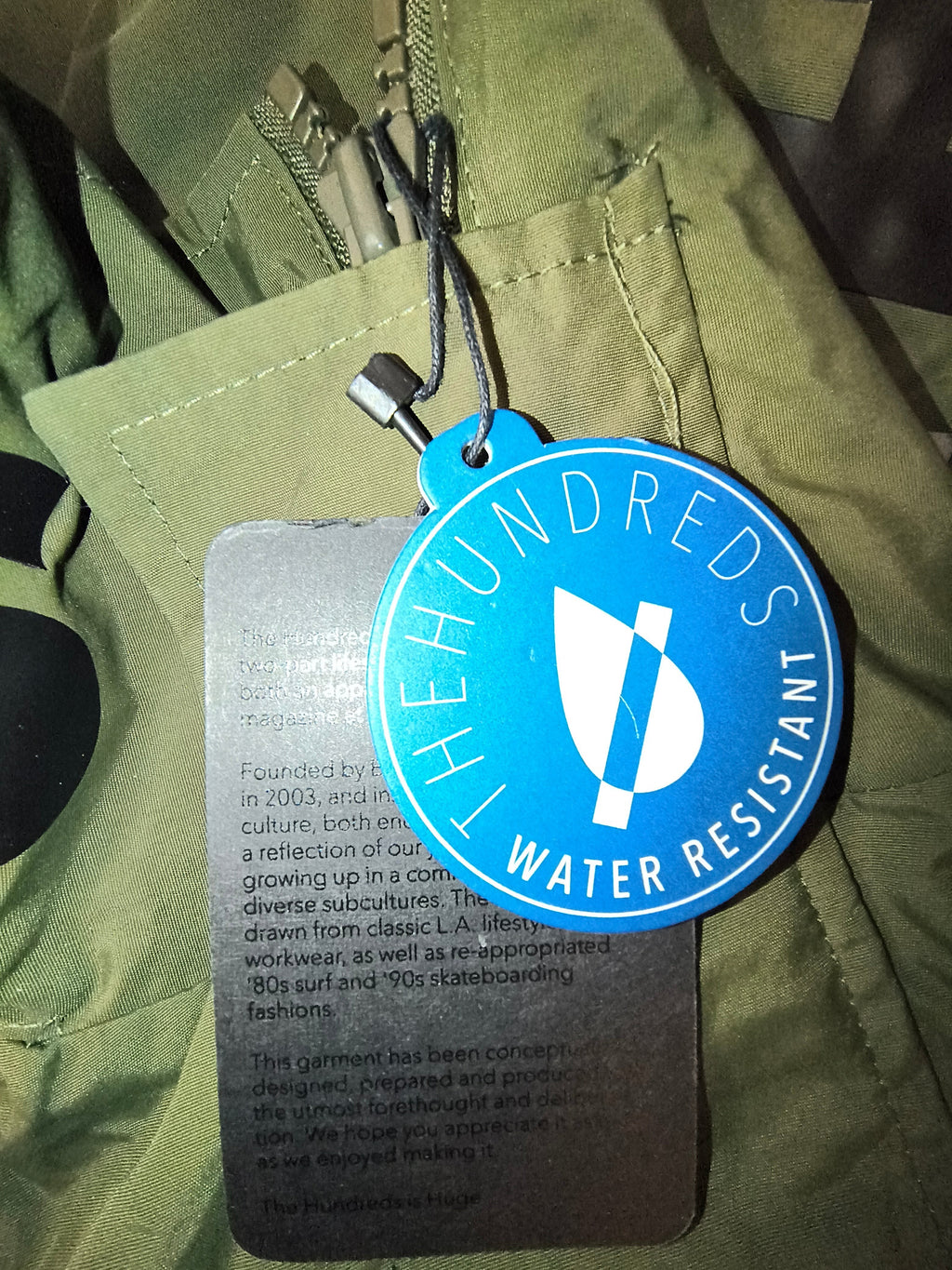 Awsum Thrift The Hundreds blue circular water-resistant product tag with white logo and brand information