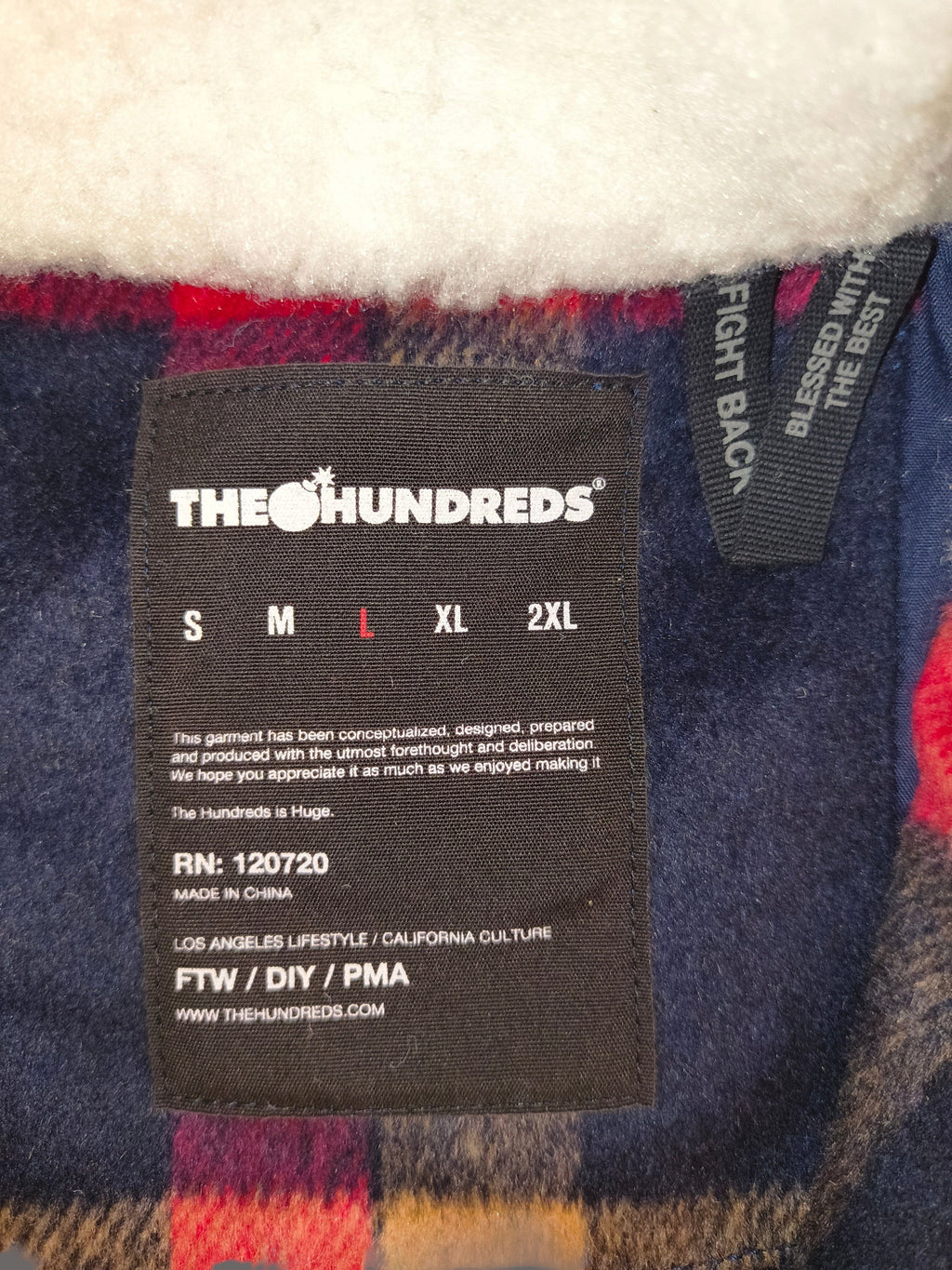Awsum Thrift The Hundreds jacket interior label with size L highlighted against a plaid flannel and sherpa lining