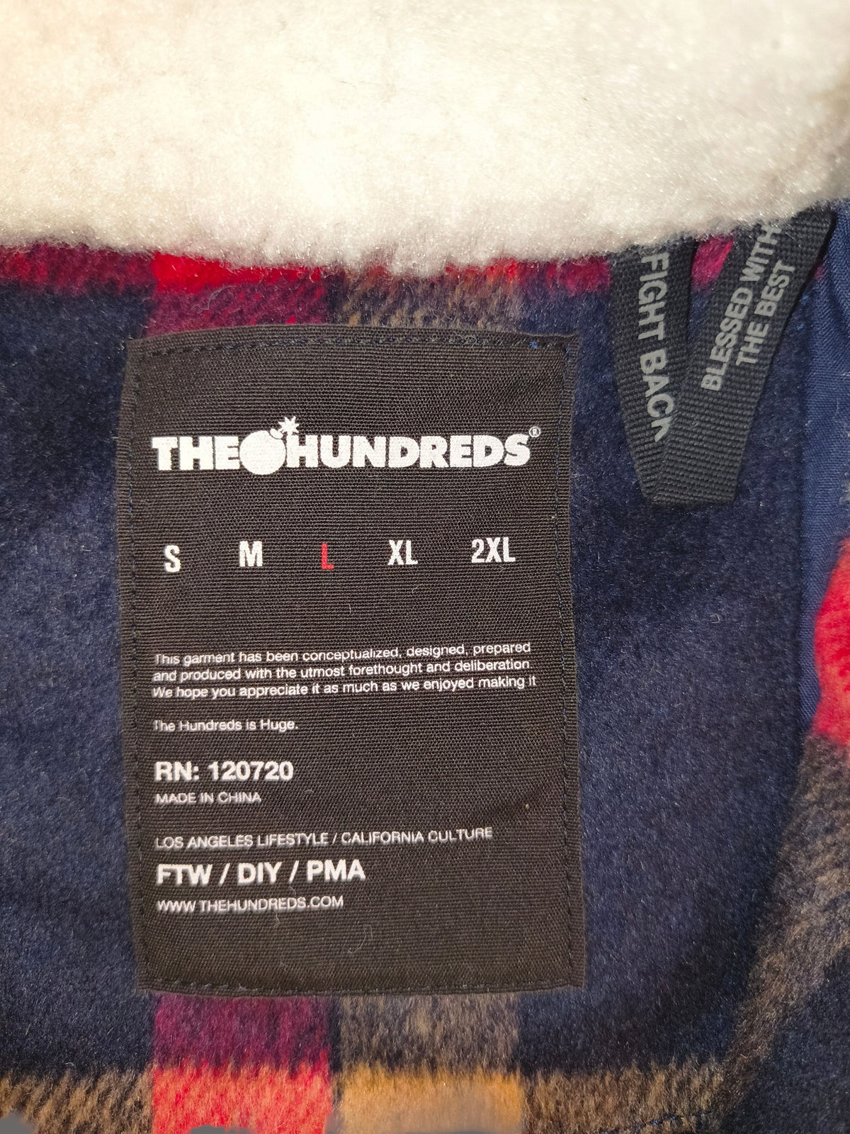 Awsum Thrift The Hundreds jacket interior label with size L highlighted against a plaid flannel and sherpa lining