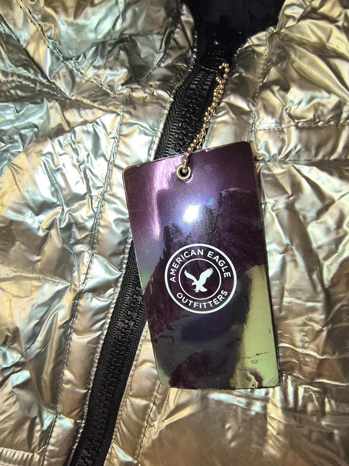 Awsum Thrift American Eagle Outfitters branded rectangular hang tag with circular logo on a metallic purple background