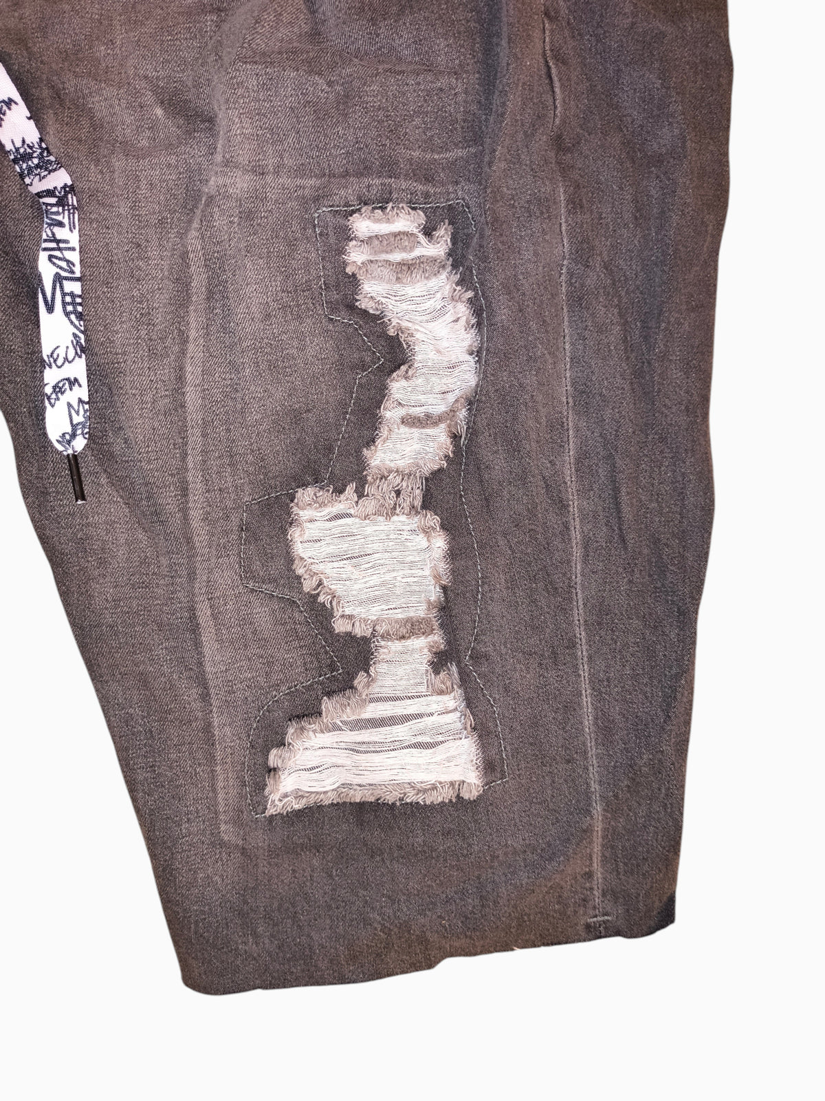 Awsum Thrift Trukfit grey distressed denim shorts with shredded panels and graphic print drawstring detail.