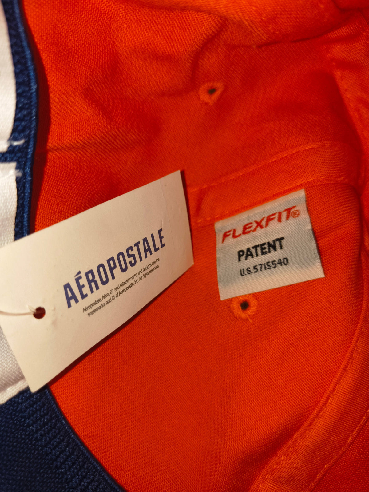 Awsum Thrift Aéropostale Flexfit hat interior showing brand hangtag and official Flexfit patent label on orange fabric