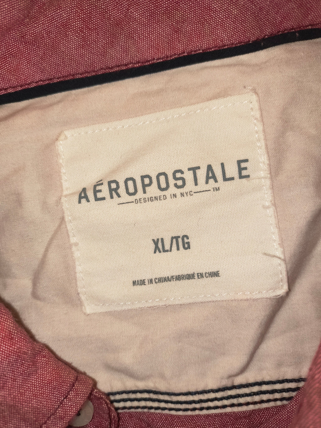 Awsum Thrift Aeropostale button up shirt label showing size XL TG on a light pink and white fabric background