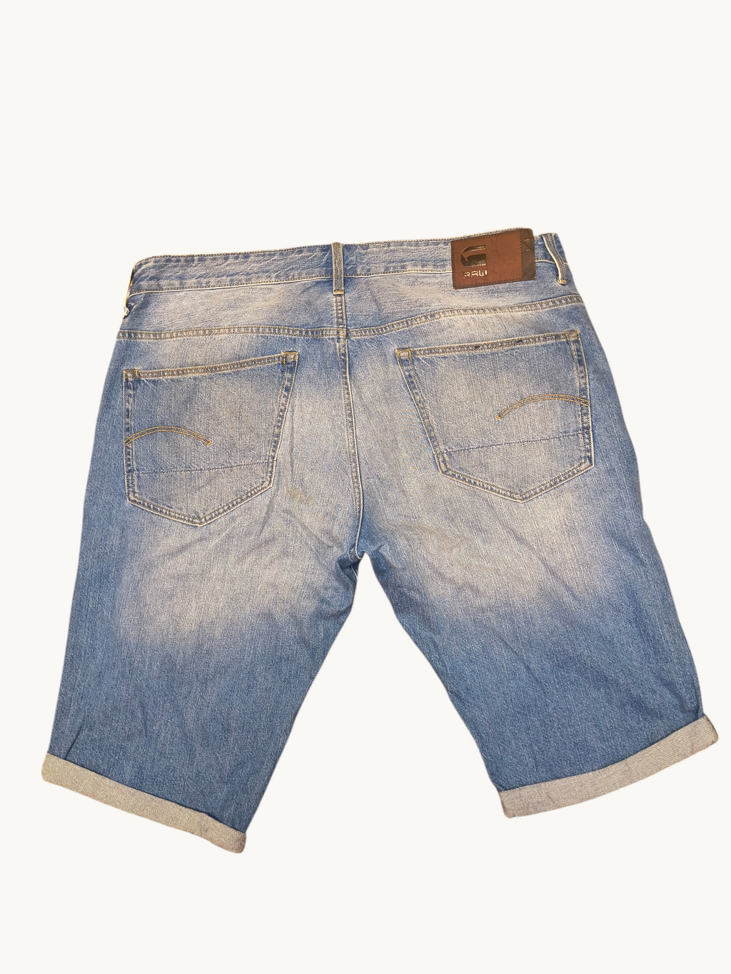 Awsum Thrift G-Raw blue denim jean shorts with a back leather patch and cuffed hems.