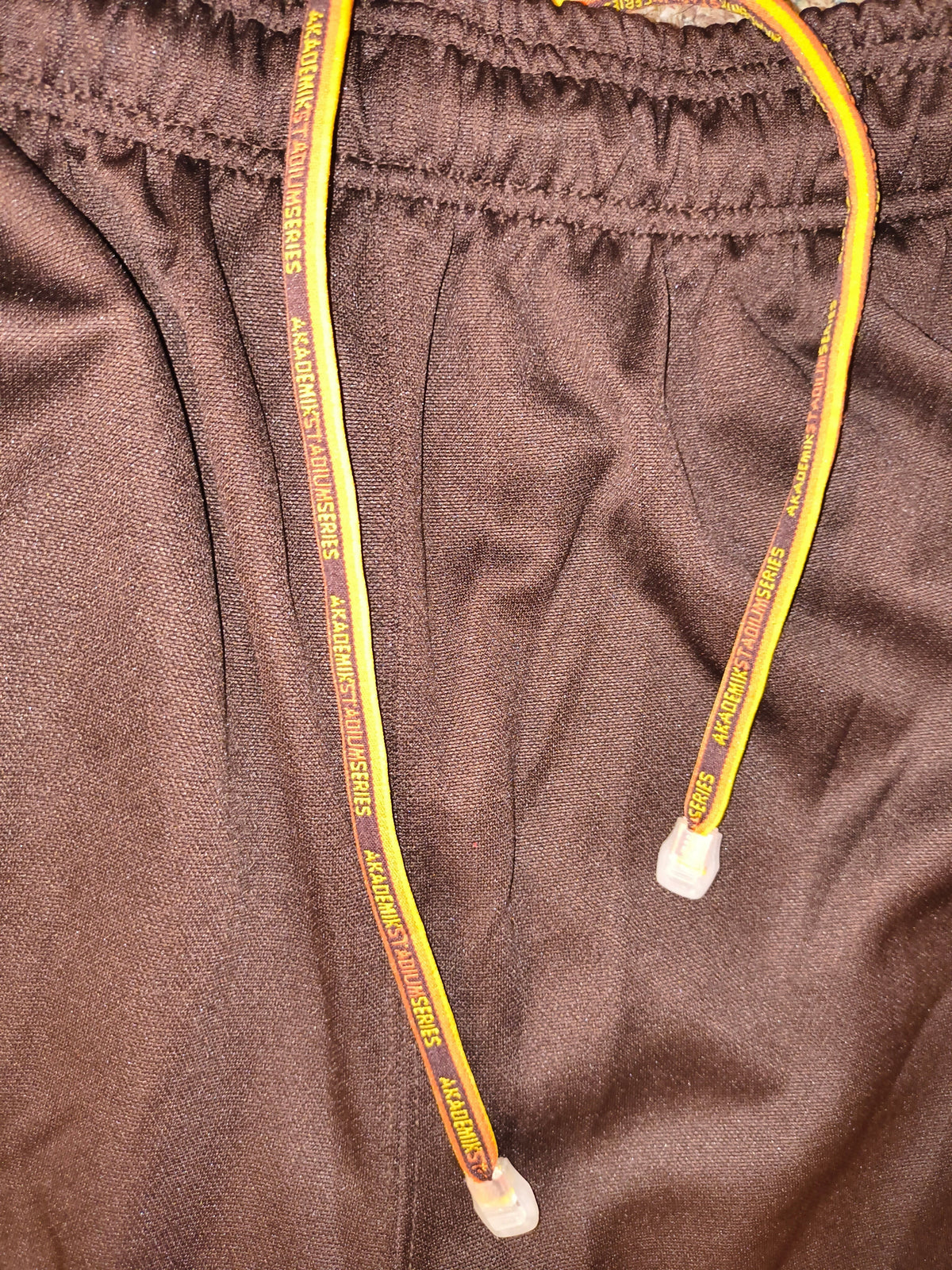 Awsum Thrift vintage Akademiks track pants featuring chocolate brown polyester fabric and branded Stadium Series drawstrings