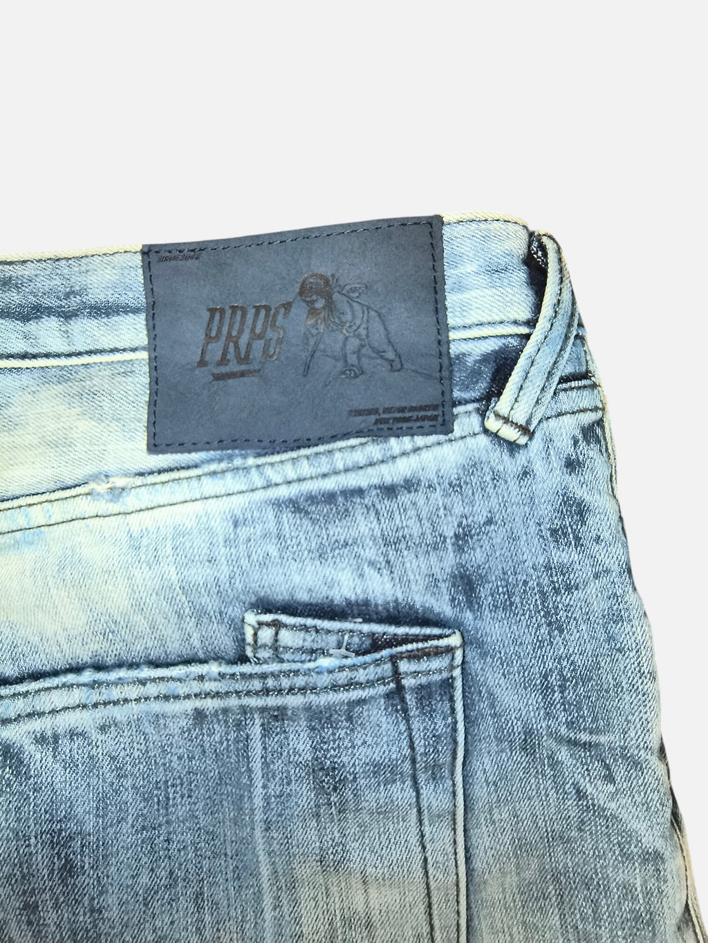 Awsum Thrift PRPS jeans featuring a light blue distressed denim wash and a dark leather brand patch on the back waist