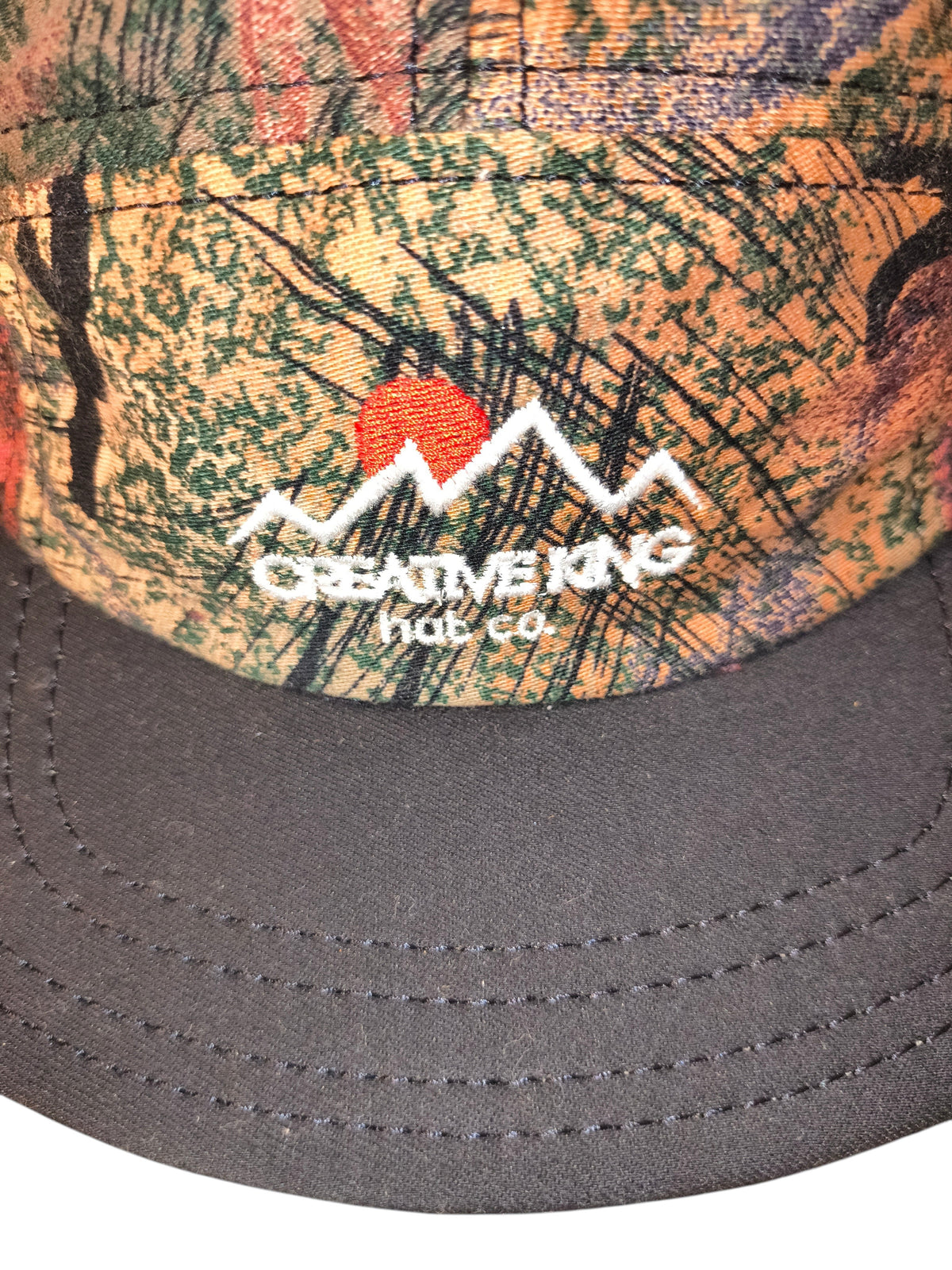 Awsum Thrift Creative King Hat Co. 5-panel camper hat with earth-toned camo tapestry and mountain logo embroidery.