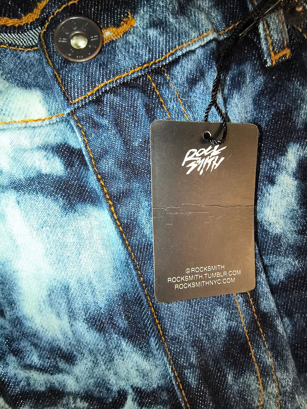 Awsum Thrift Rocksmith NYC branded black paper hangtag with white logo and website details on a black string
