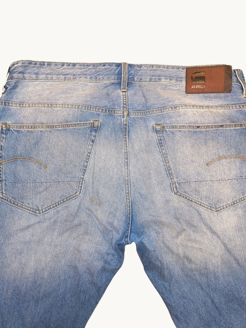 Awsum Thrift G-Raw light wash denim jean shorts featuring a brown leather back patch and signature pocket stitching.