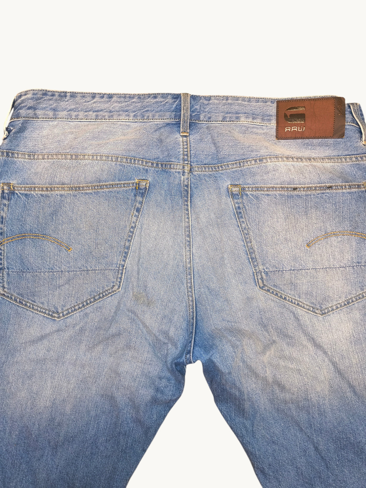 Awsum Thrift G-Raw light wash denim jean shorts featuring a brown leather back patch and signature pocket stitching.