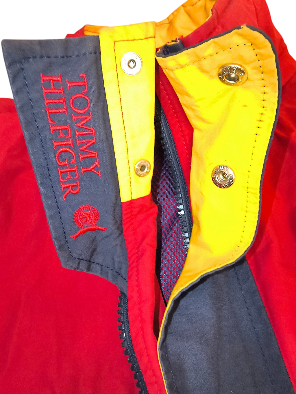 Awsum Thrift vintage Tommy Hilfiger jacket in red, yellow, and navy with embroidered logo and hideaway hood detail