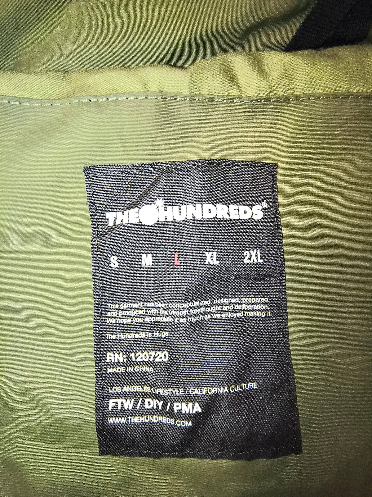 Awsum Thrift The Hundreds black fabric size tag for a men's large jacket with brand logo and care details