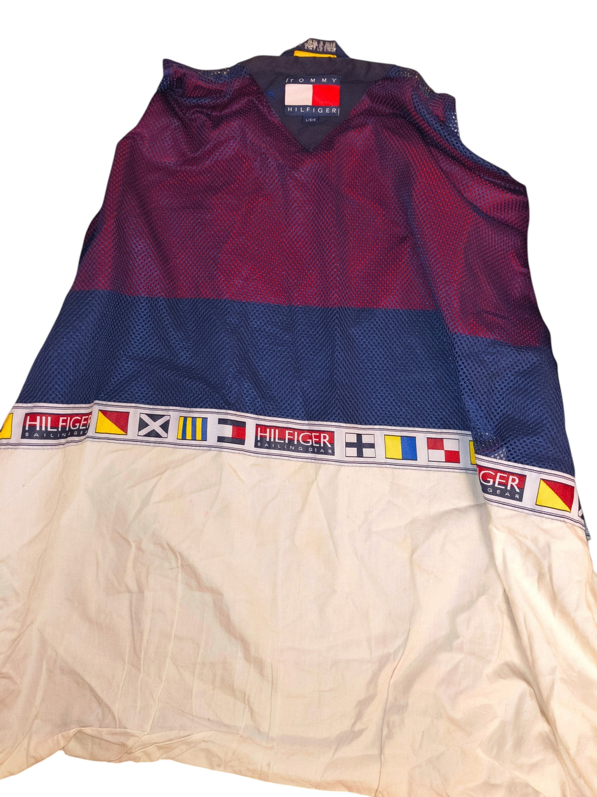 Awsum Thrift vintage Tommy Hilfiger sailing jacket in cream, blue, and red mesh with a nautical flag stripe detail.