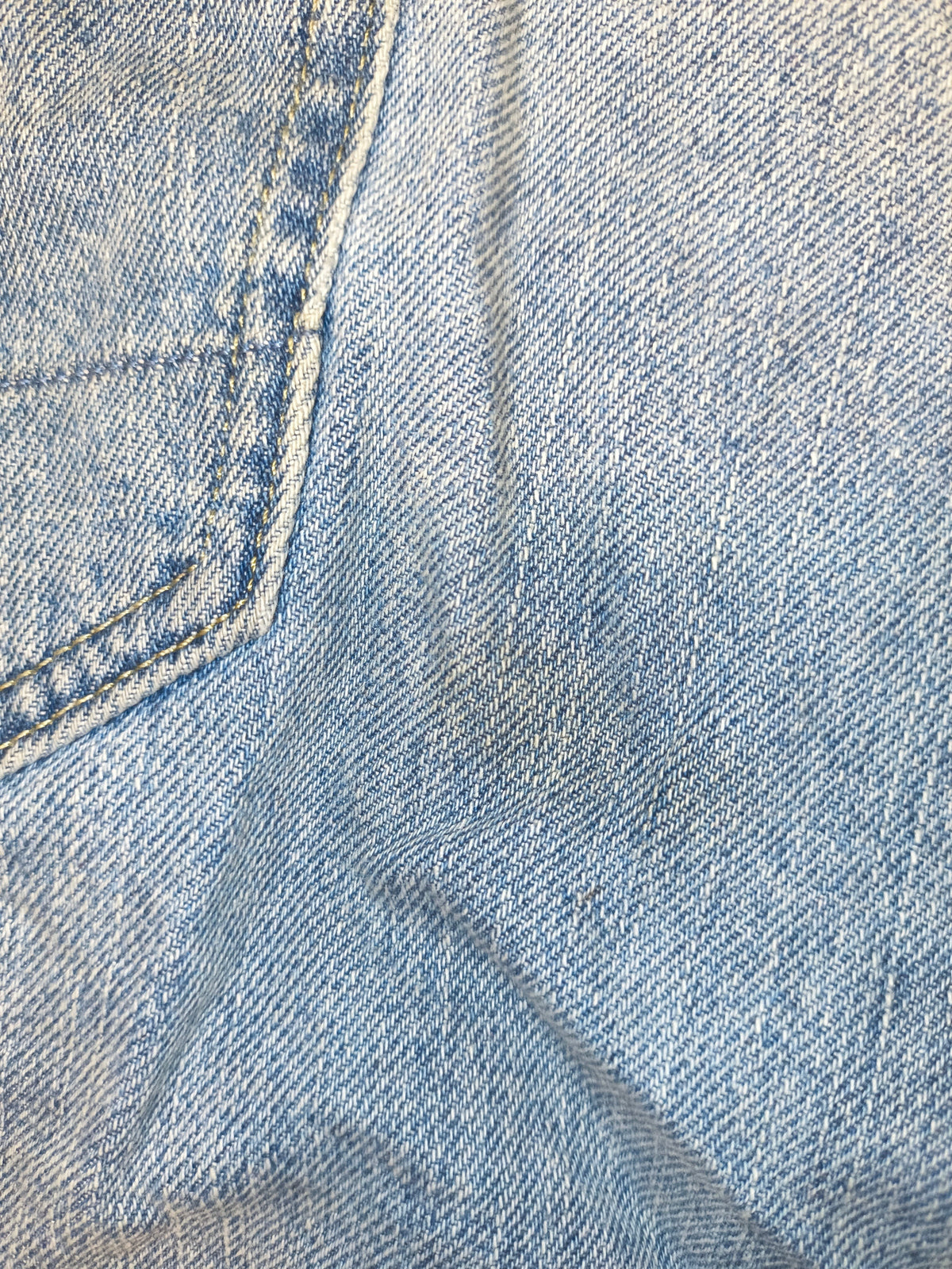 Close-up of light blue denim fabric from Awsum Thrift G-Raw jean shorts with visible stitching and texture