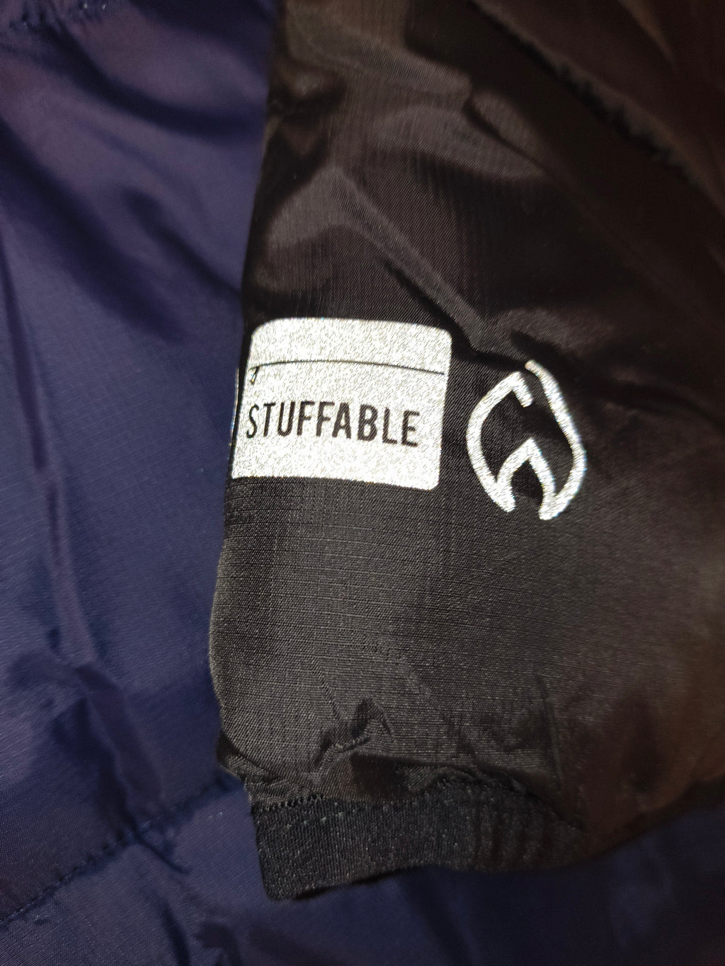 Awsum Thrift All Good High Camp puffer jacket sleeve with reflective Stuffable graphic and logo detail