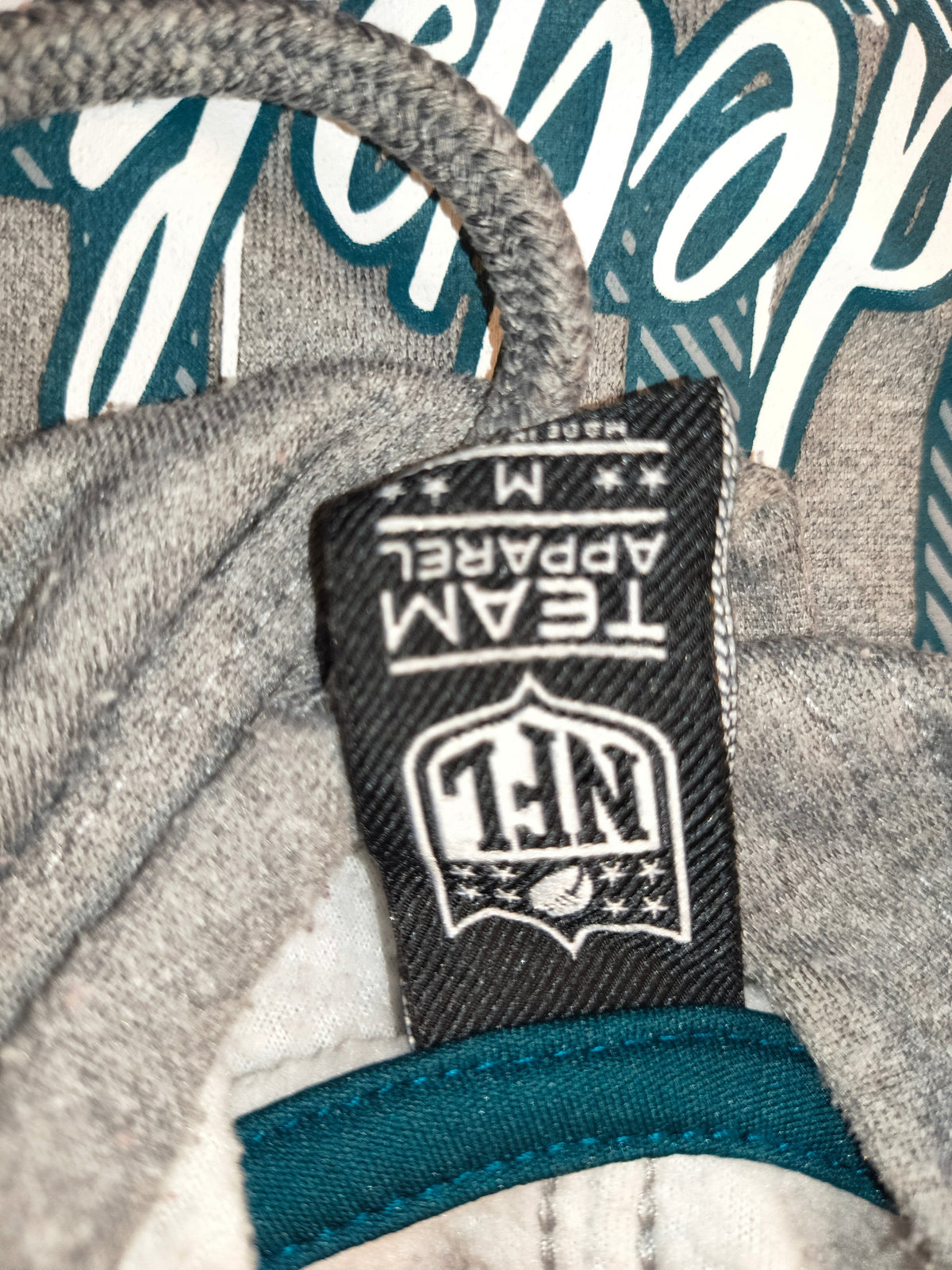 Awsum Thrift NFL Team Apparel Philadelphia Eagles hoodie neck label showing size M and official NFL branding