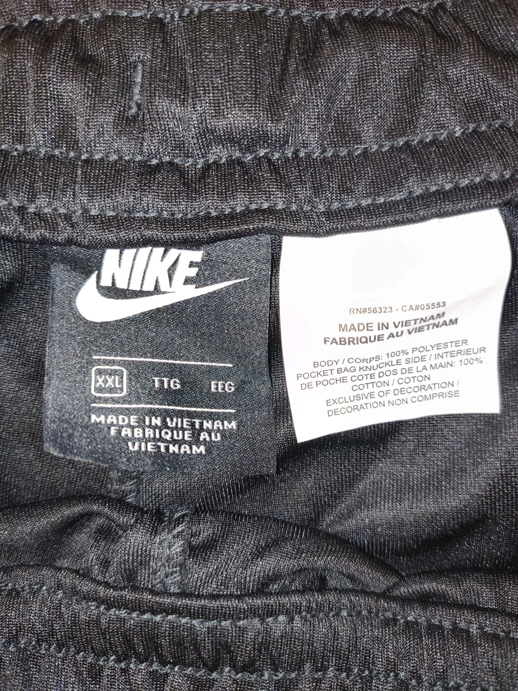 Awsum Thrift black Nike polyester pants interior care label showing size XXL and Vietnam manufacturing details