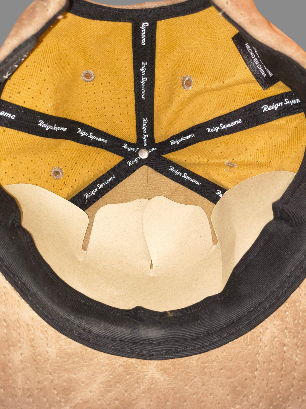 Interior of Awsum Thrift King Apparel snapback hat featuring gold mesh lining and Reign Supreme branded seam tape